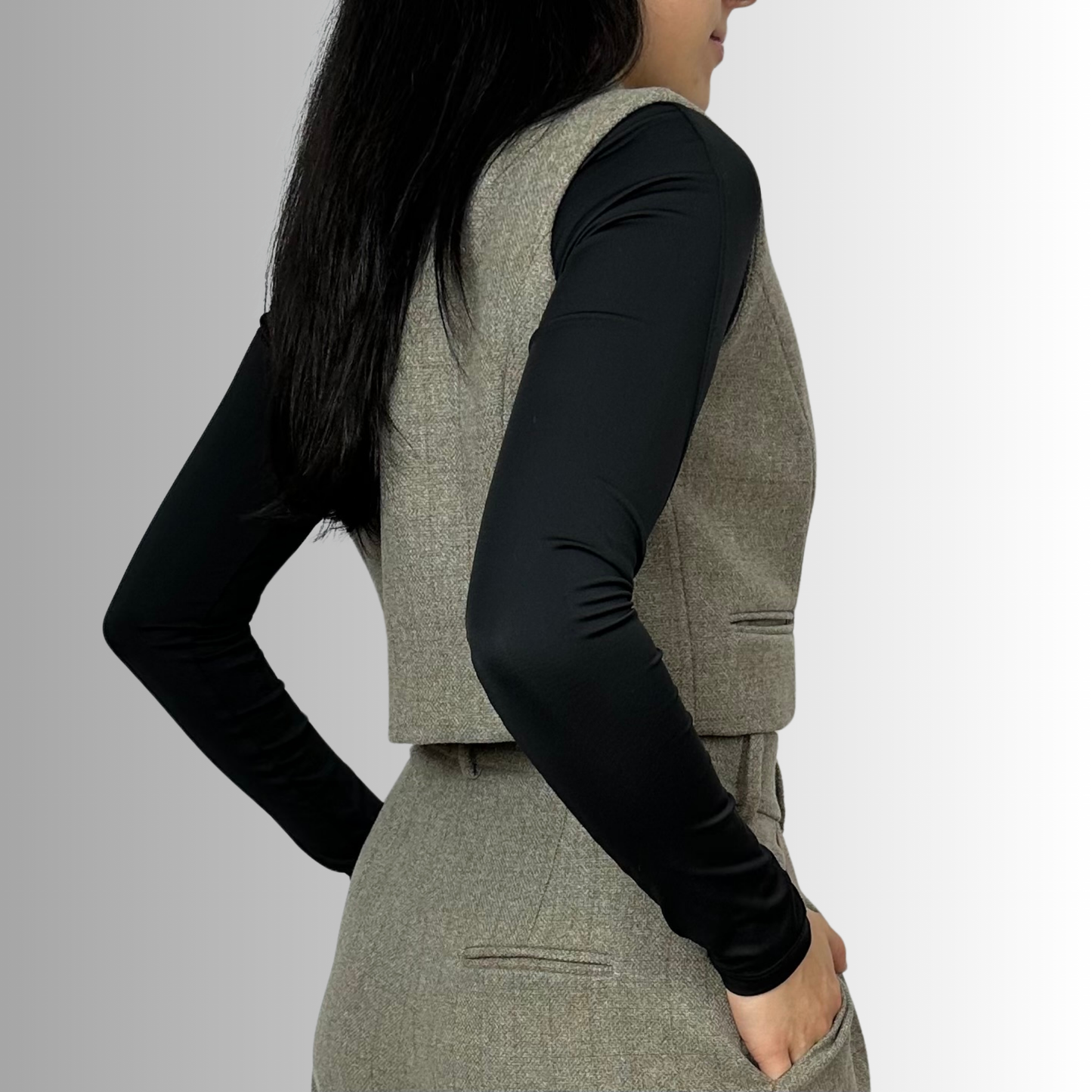 Back view of a woman wearing Sartorial Flair’s Zeo waistcoat in heather gray, displaying the sleek tailoring and clean back design.