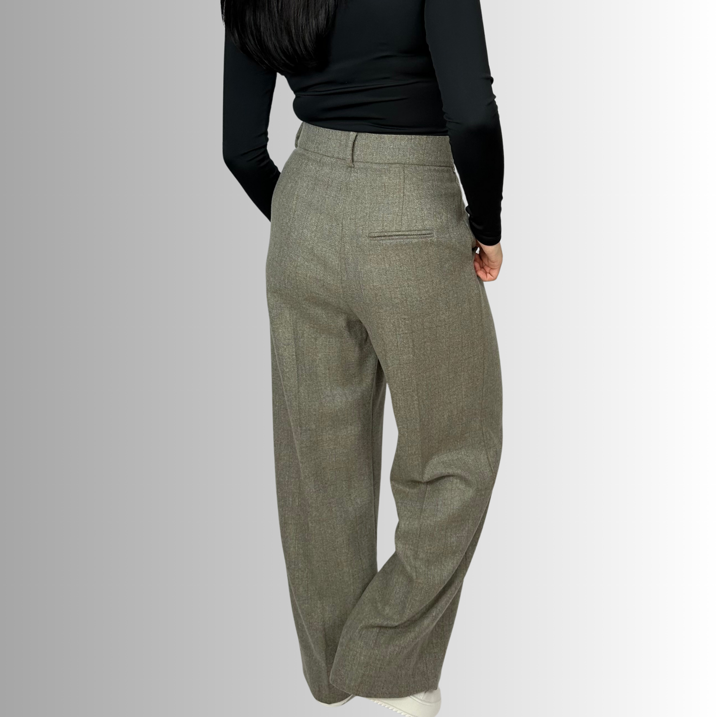 Rear view of a woman in Sartorial Flair’s Zeo wide wool trousers in heather gray, showcasing the fit and elegant tailoring along with a high-waisted back