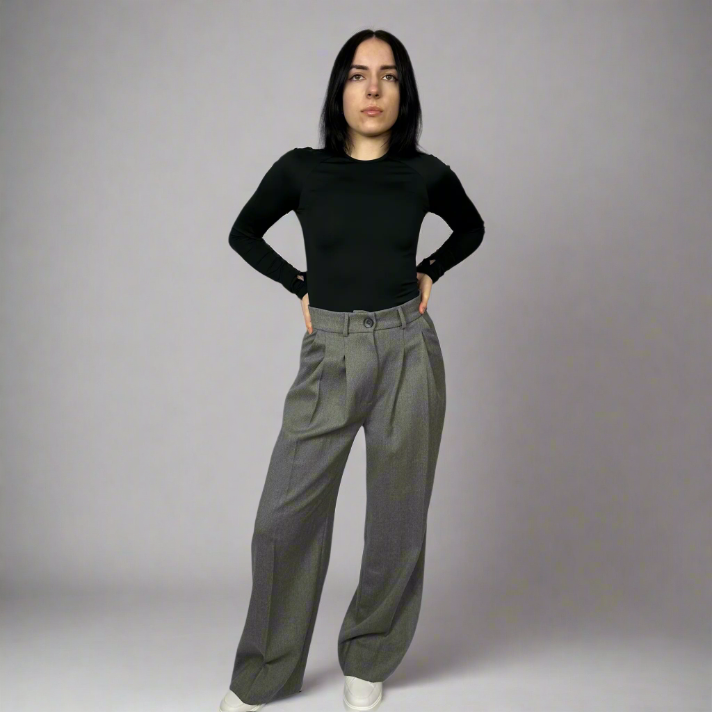 Model casually posing with one hand on hip in Isabella Charcoal Trousers, illustrating the versatile design suitable for both formal and casual settings.