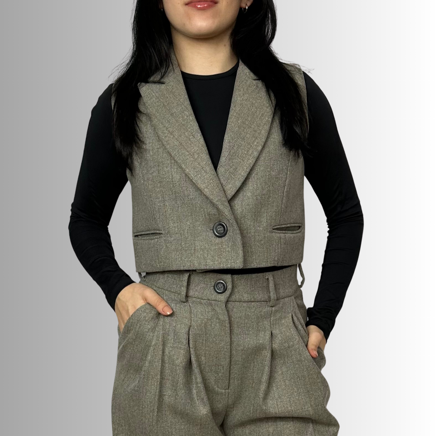 Close-up of Sartorial Flair’s heather gray Zeo waistcoat showing a single-button closure, styled over a black top, focusing on the detailed craftsmanship.