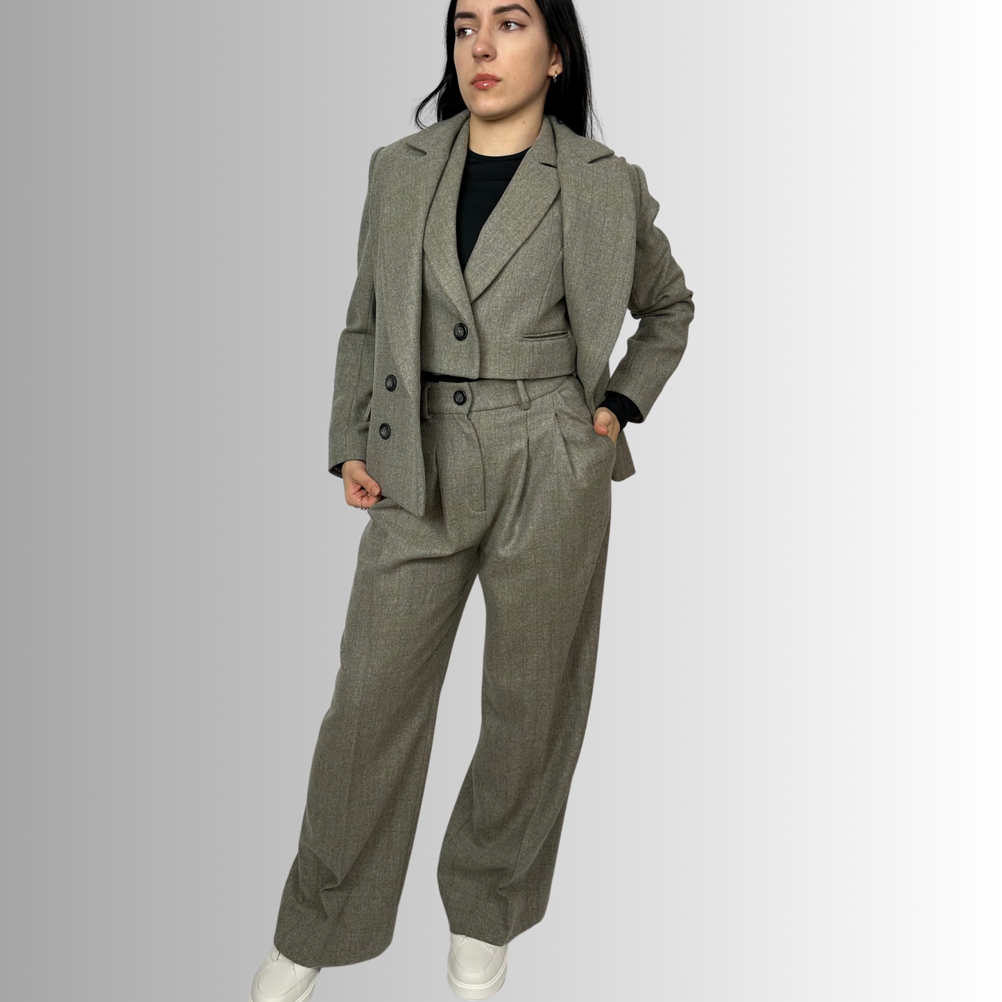 Full-length front view of a woman wearing Sartorial Flair’s Zeo blazer and high-waisted wool trousers in heather gray, eco-friendly women’s suit.